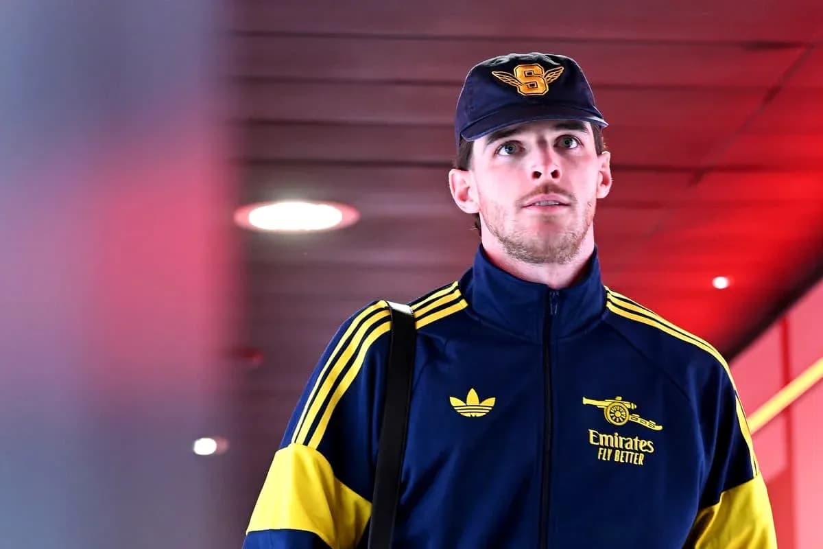 Player in Arsenal tracksuit walking through corridor