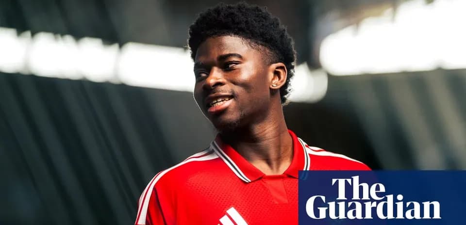 Player wearing red jersey smiling during photoshoot