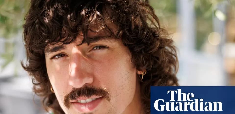 Young man with curly hair and mustache