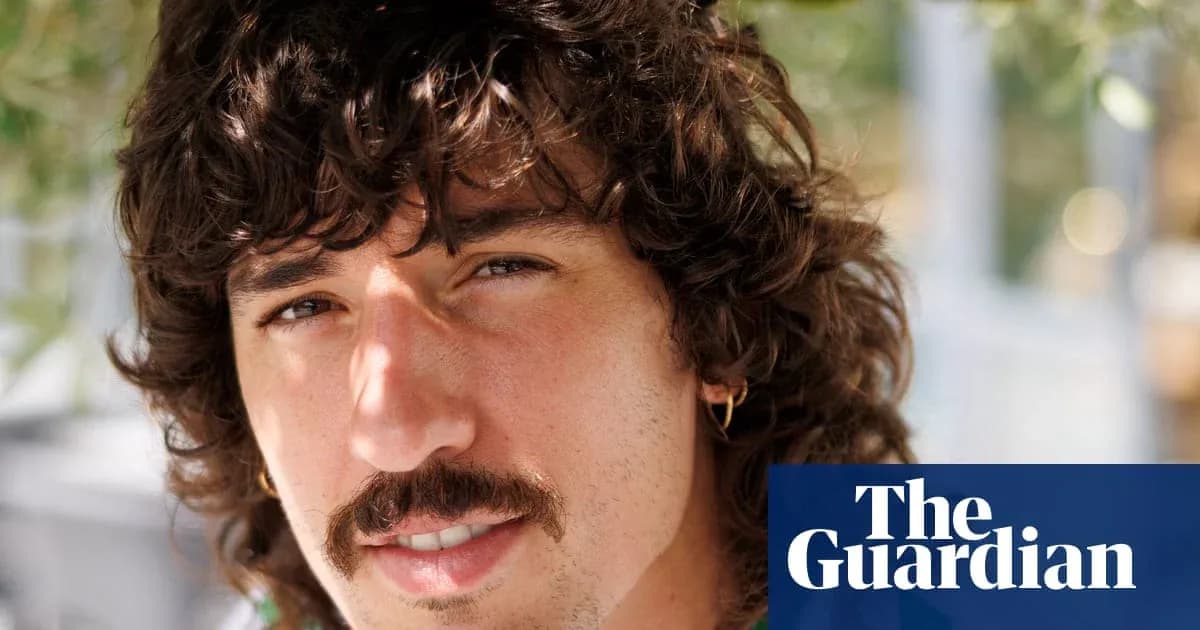 Young man with curly hair and mustache