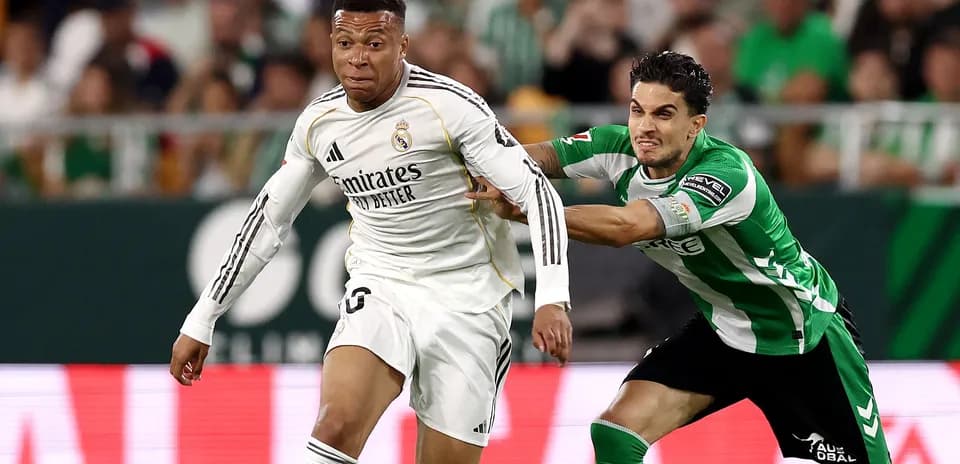 Player in white evading tackle from opponent in green