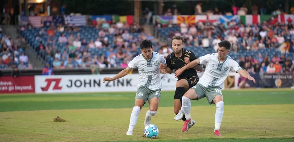 Two players competing for the ball in football match