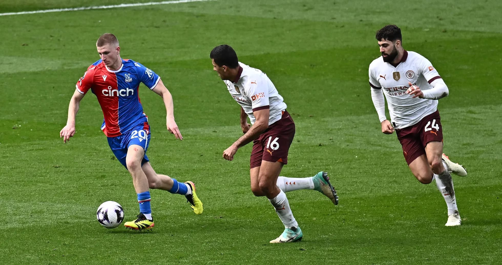 Player in red and blue jersey dribbling ball past defenders