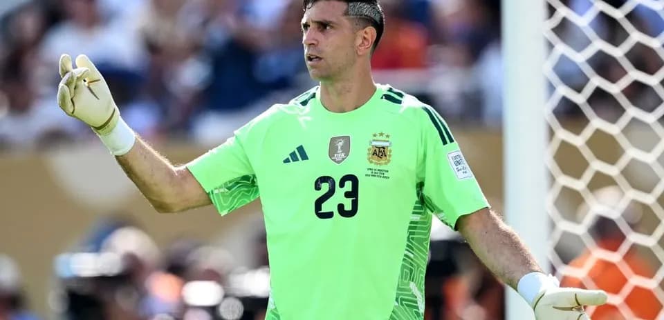 Goalkeeper in green jersey signaling during match