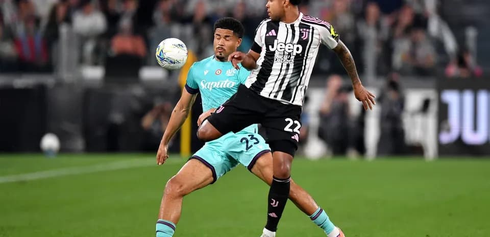 Juventus player challenging Bologna opponent for the ball