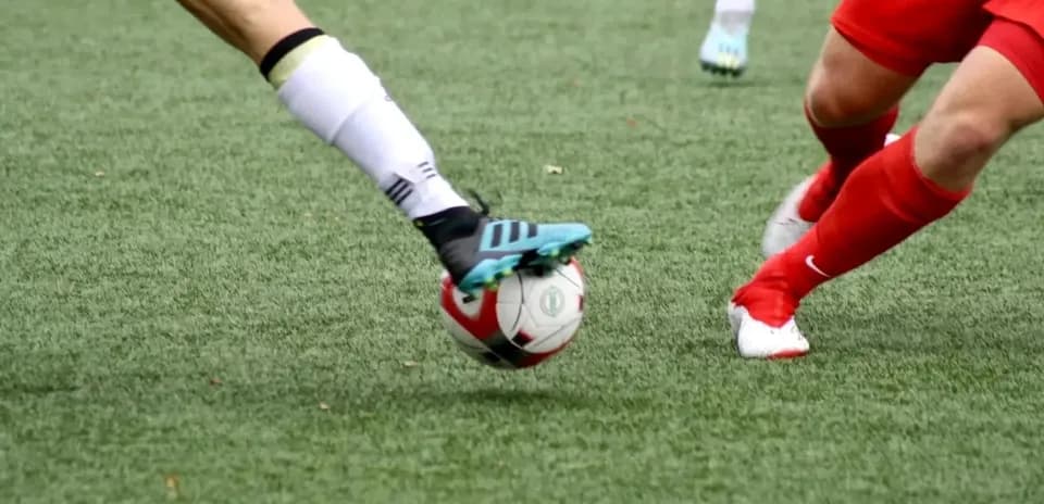 Players competing for the ball in football match