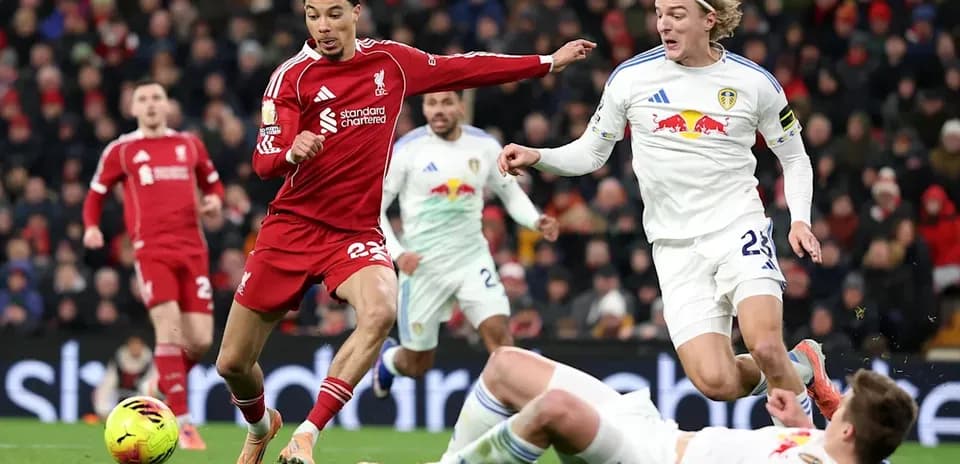 Liverpool and Leeds players contesting the ball on field