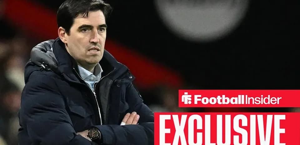 Coach with arms crossed on sidelines during match