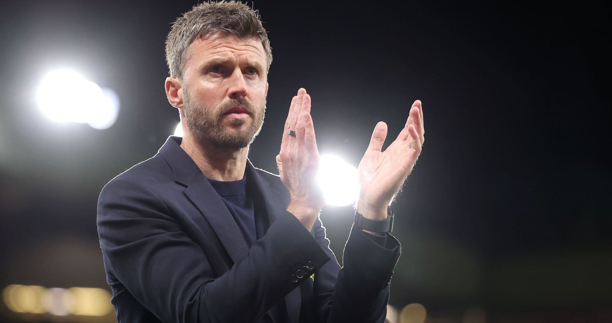 Manager applauding during a match at night