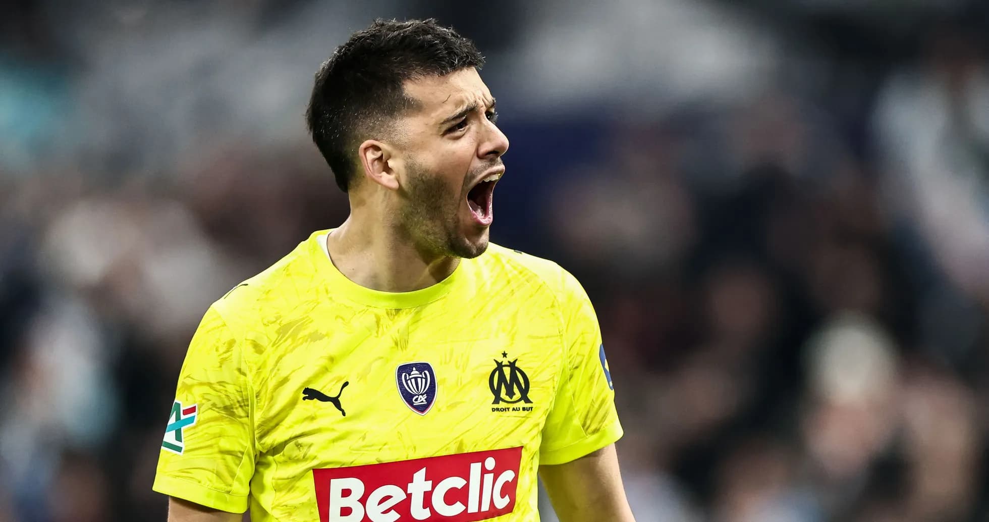 Goalkeeper shouting during a match in yellow kit
