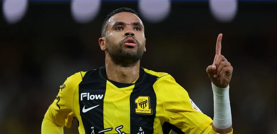 Player celebrating a goal wearing yellow and black jersey