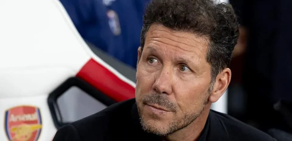 Coach seated on bench during match preparation