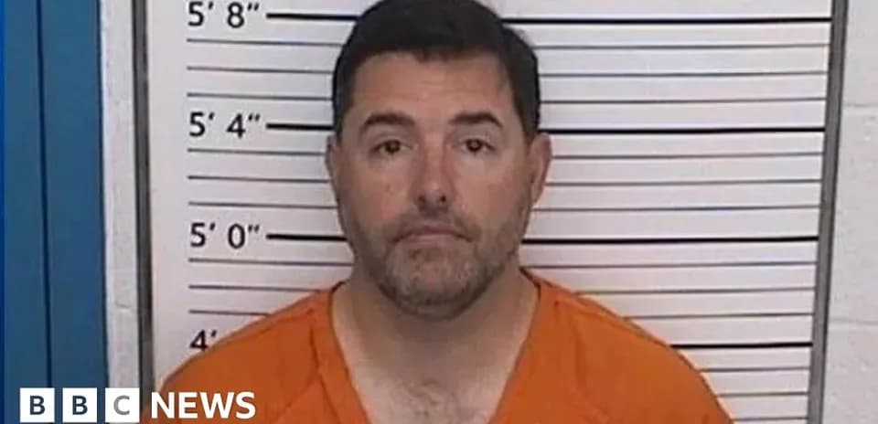 Man in orange jumpsuit at height chart backdrop