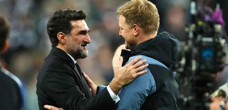Two football managers embracing after a match