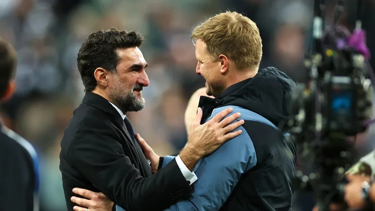 Two football managers embracing after a match