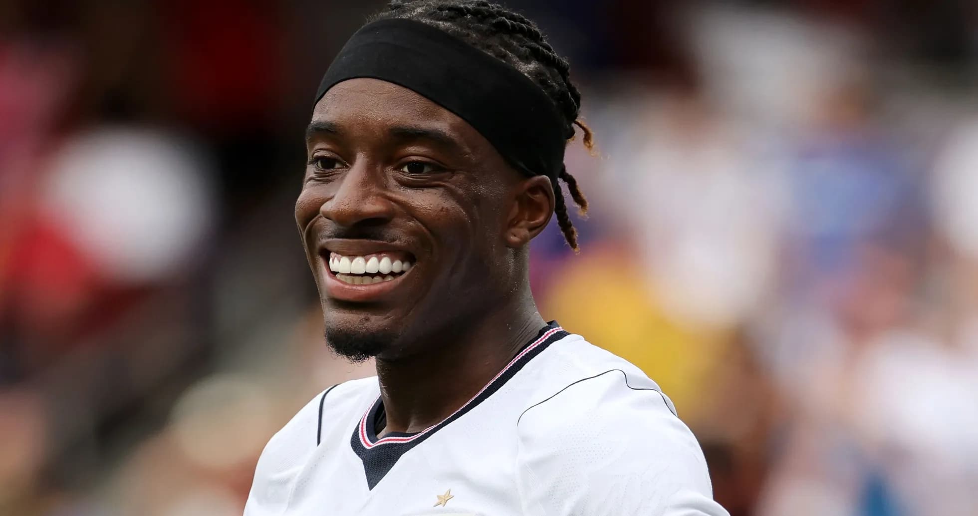 Player smiling while wearing team jersey on field