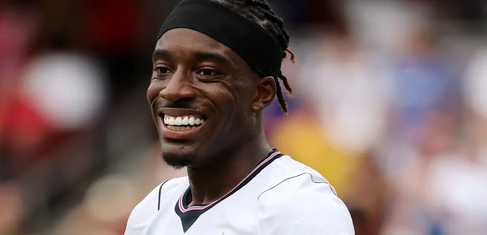 Player smiling while wearing team jersey on field