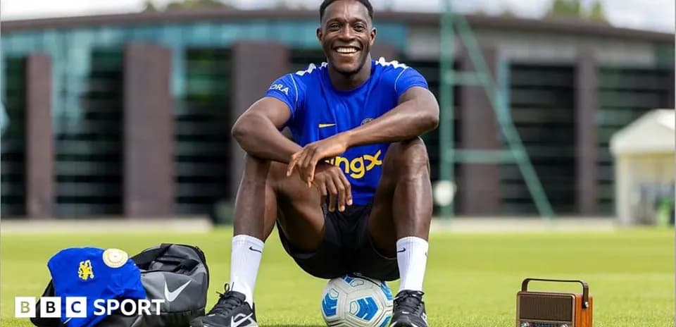 Player sitting on field with soccer ball and bag