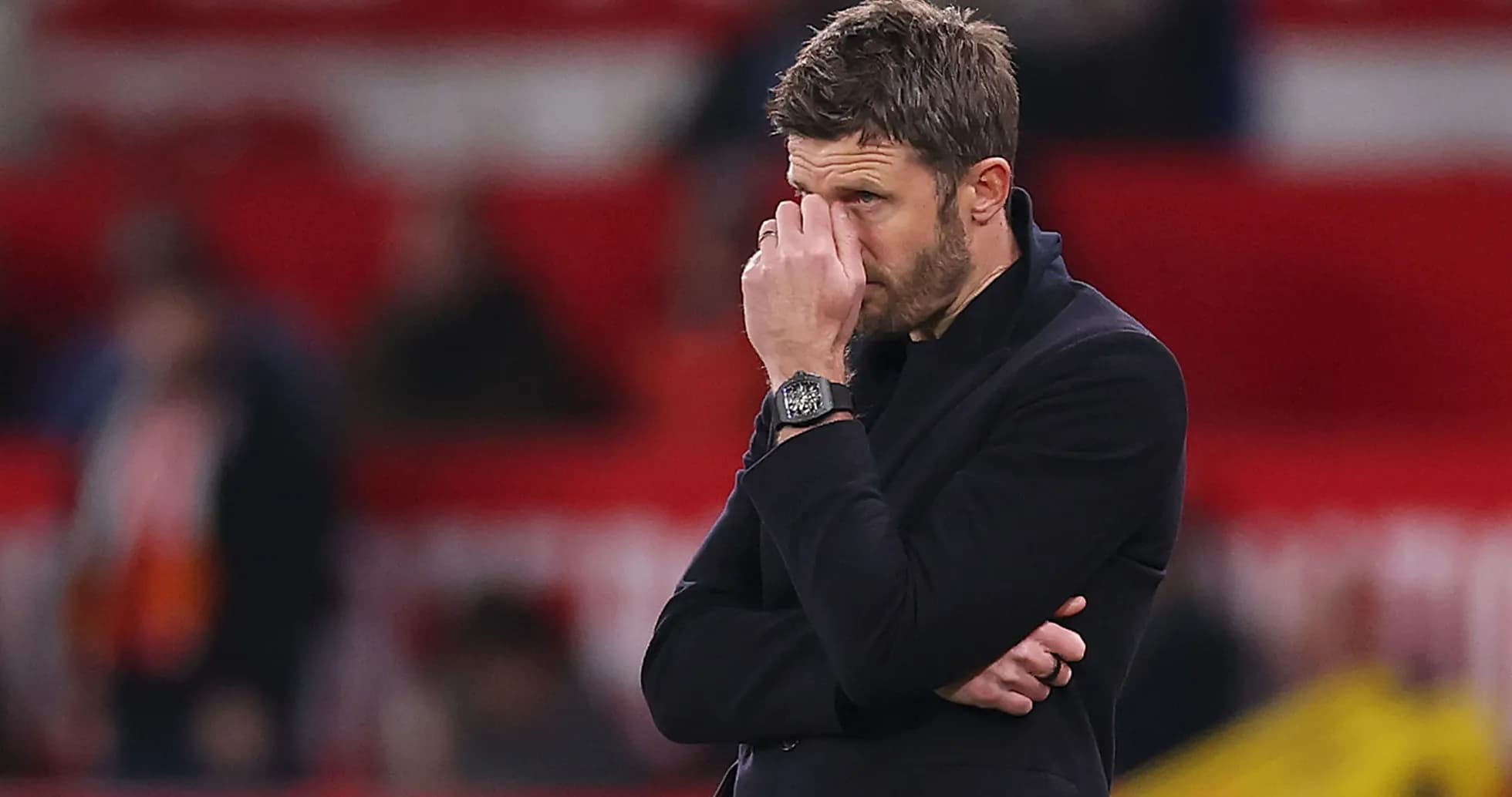 Coach with hand on face during match