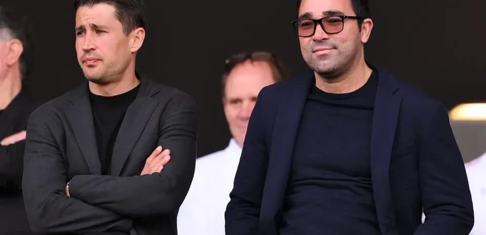 Two men seated in stands during an event