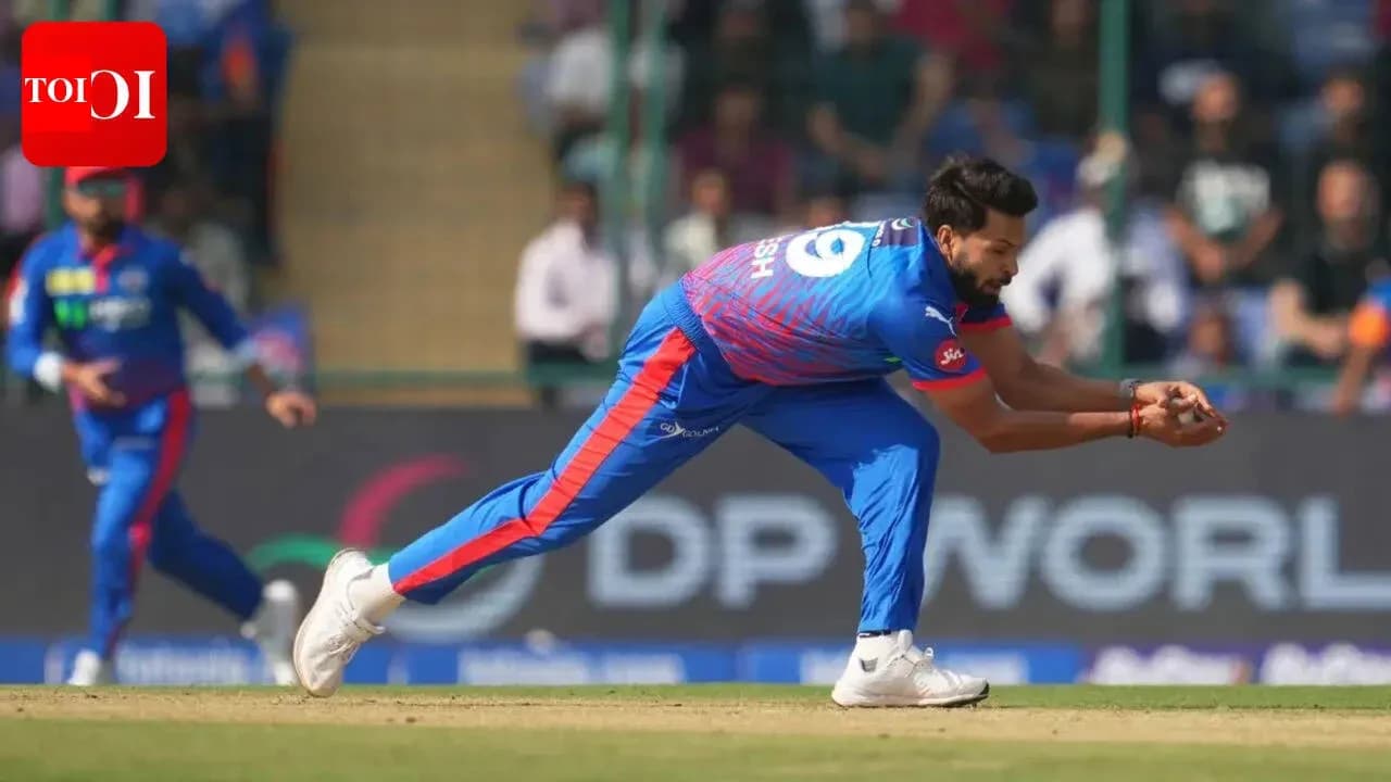 Fielder diving to catch a cricket ball