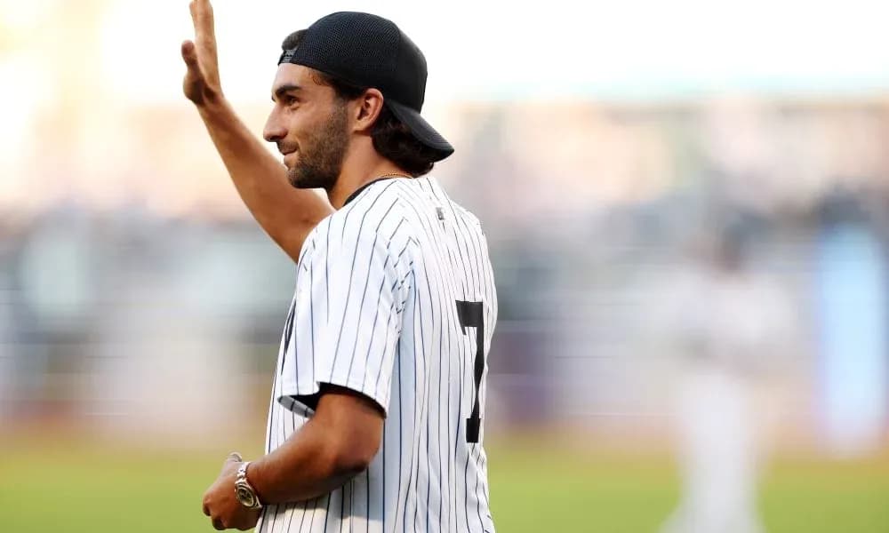 Man waving while wearing a baseball jersey