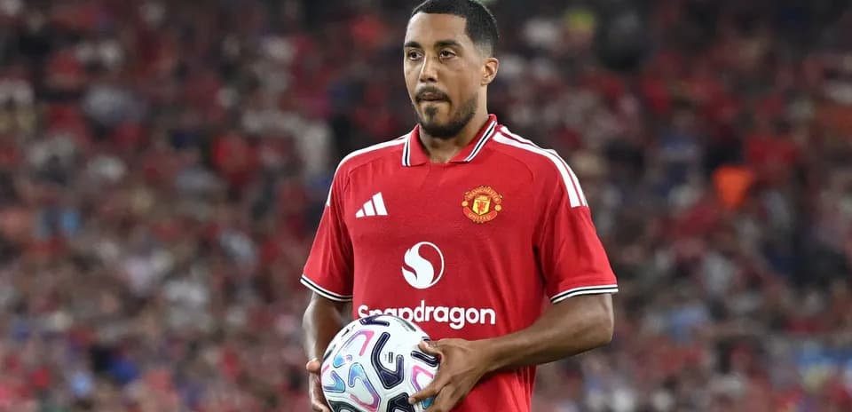Player in Manchester United jersey holding a ball