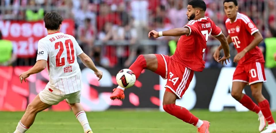 Player from RB Leipzig attempts to tackle Bayern Munich player