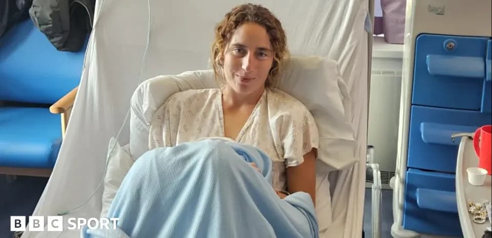 Athlete sitting in hospital bed with blanket