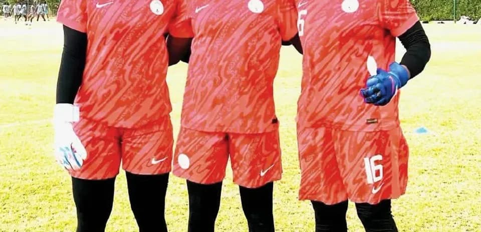 Three female soccer players posing in training gear