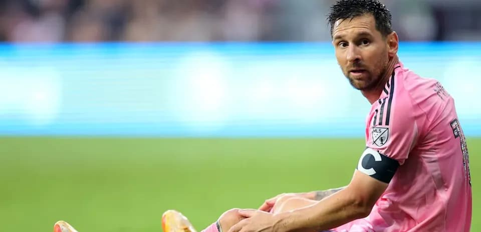 Player sitting on field during match in pink jersey