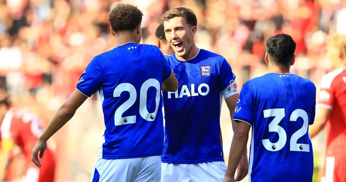 Three players celebrating on the pitch during match