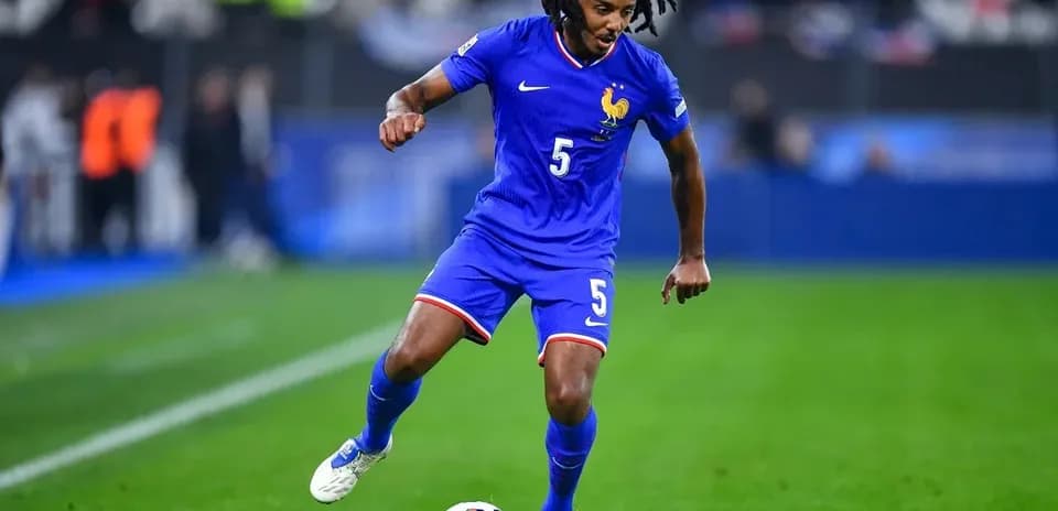 Player in blue kit dribbling ball on field