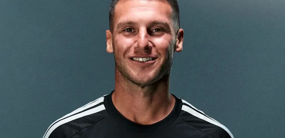 Athlete posing in team jersey with logo