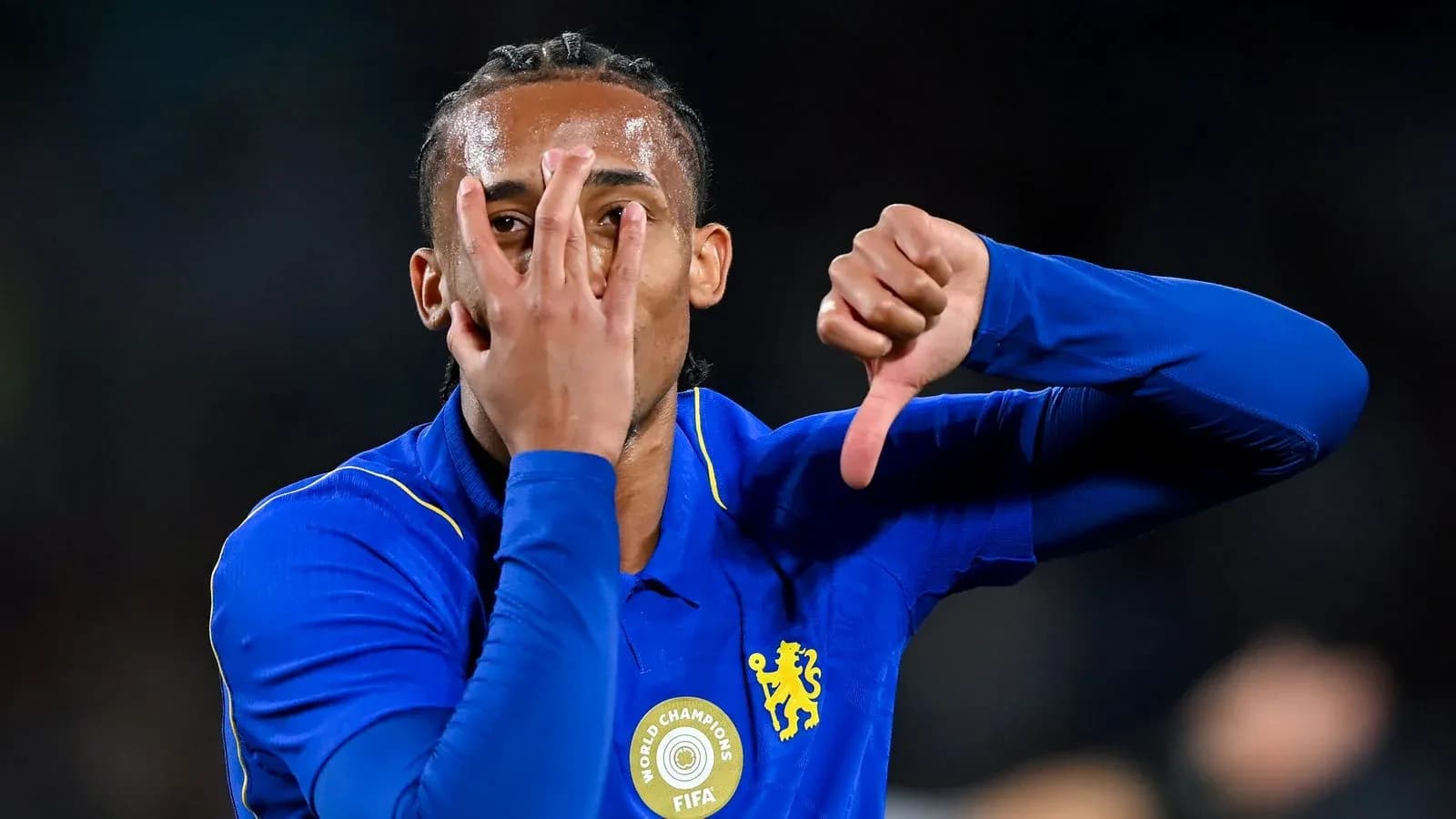 Player gesturing during match celebration in blue kit