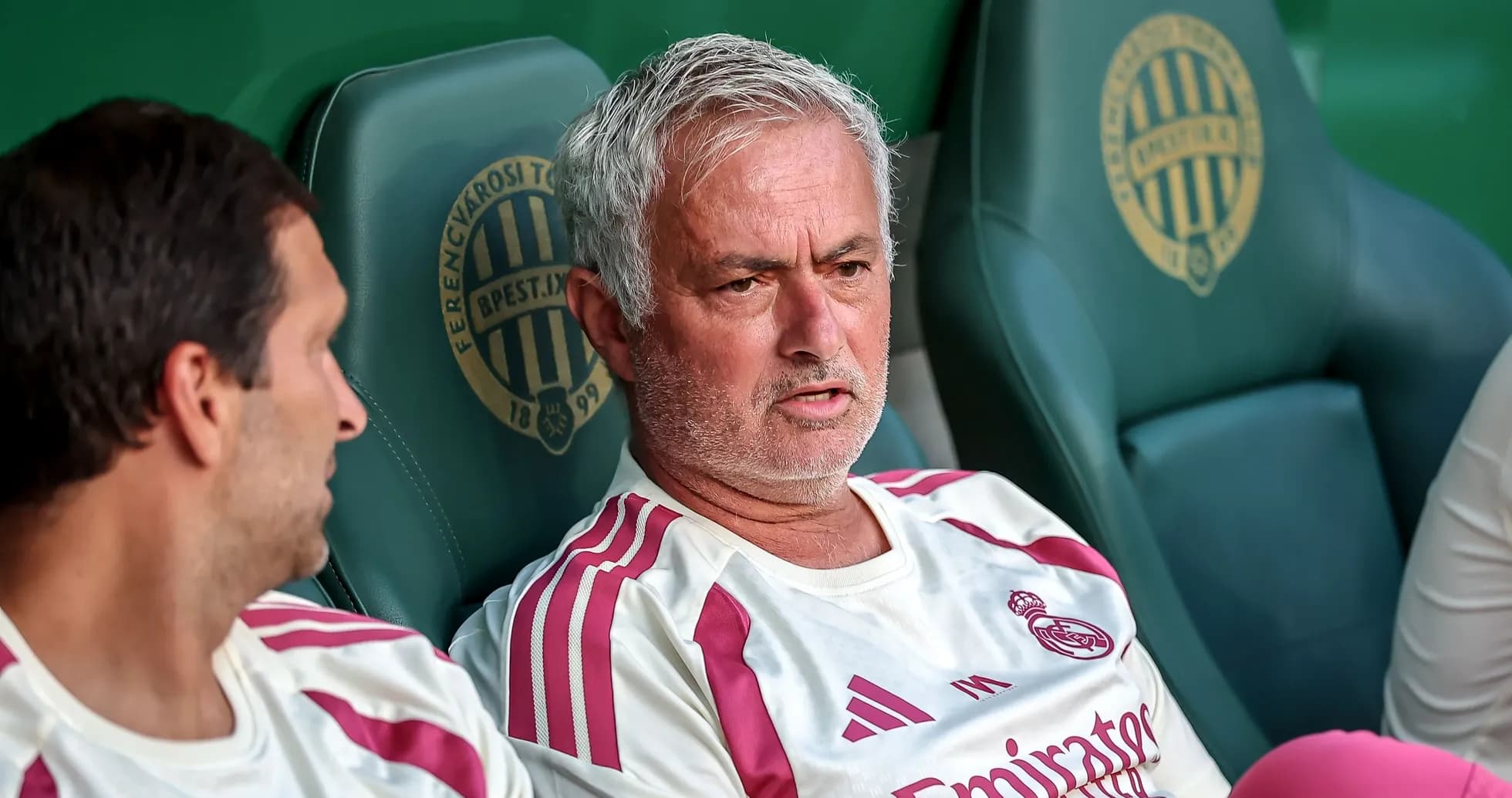 Coach sitting on bench during match with player