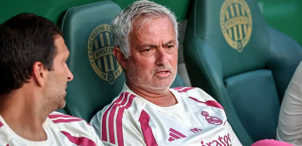 Coach sitting on bench during match with player