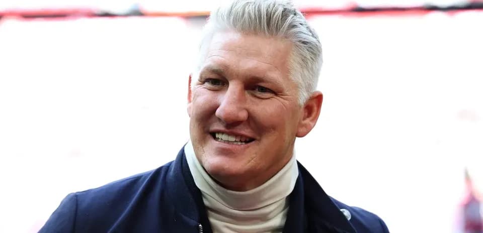 Smiling man in a jacket at stadium entrance