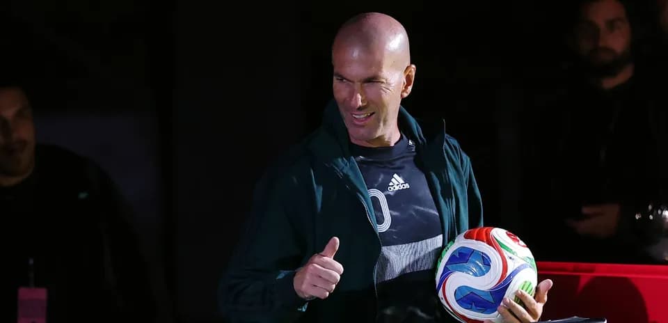 Zinedine Zidane giving a thumbs up with a soccer ball