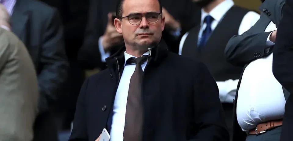 Man in suit observing from a crowded stand