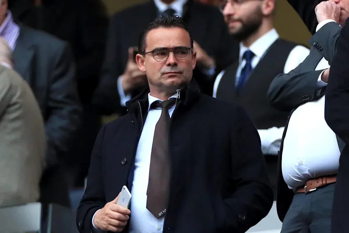 Man in suit observing from a crowded stand