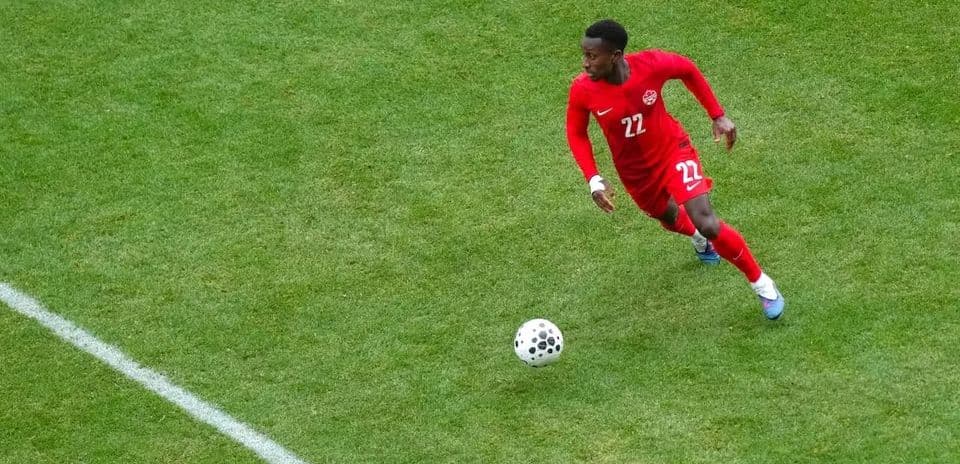 Player in red jersey dribbling the ball