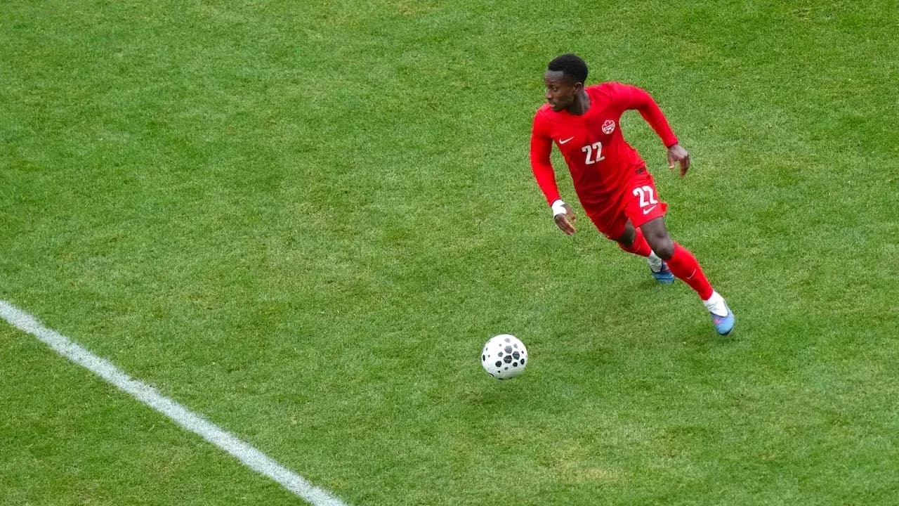 Player in red jersey dribbling the ball