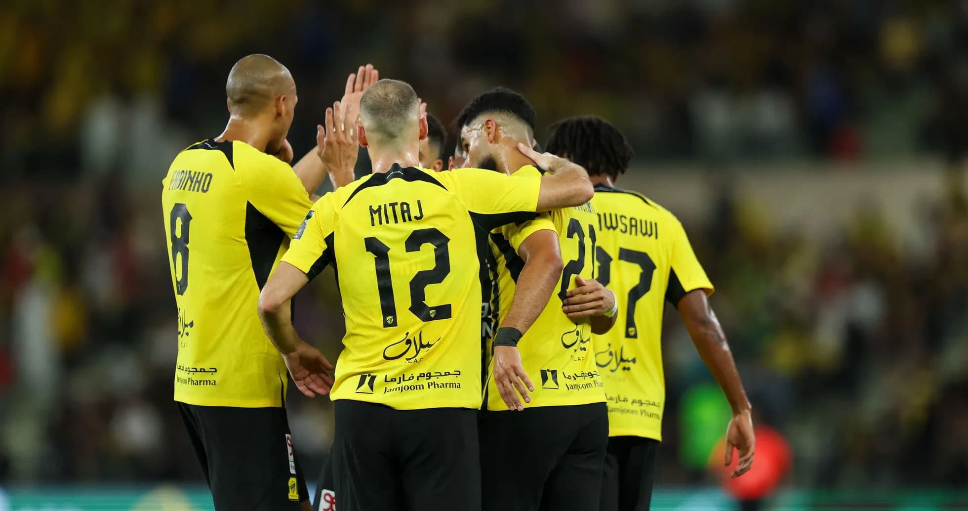 Players celebrating a goal in yellow jerseys
