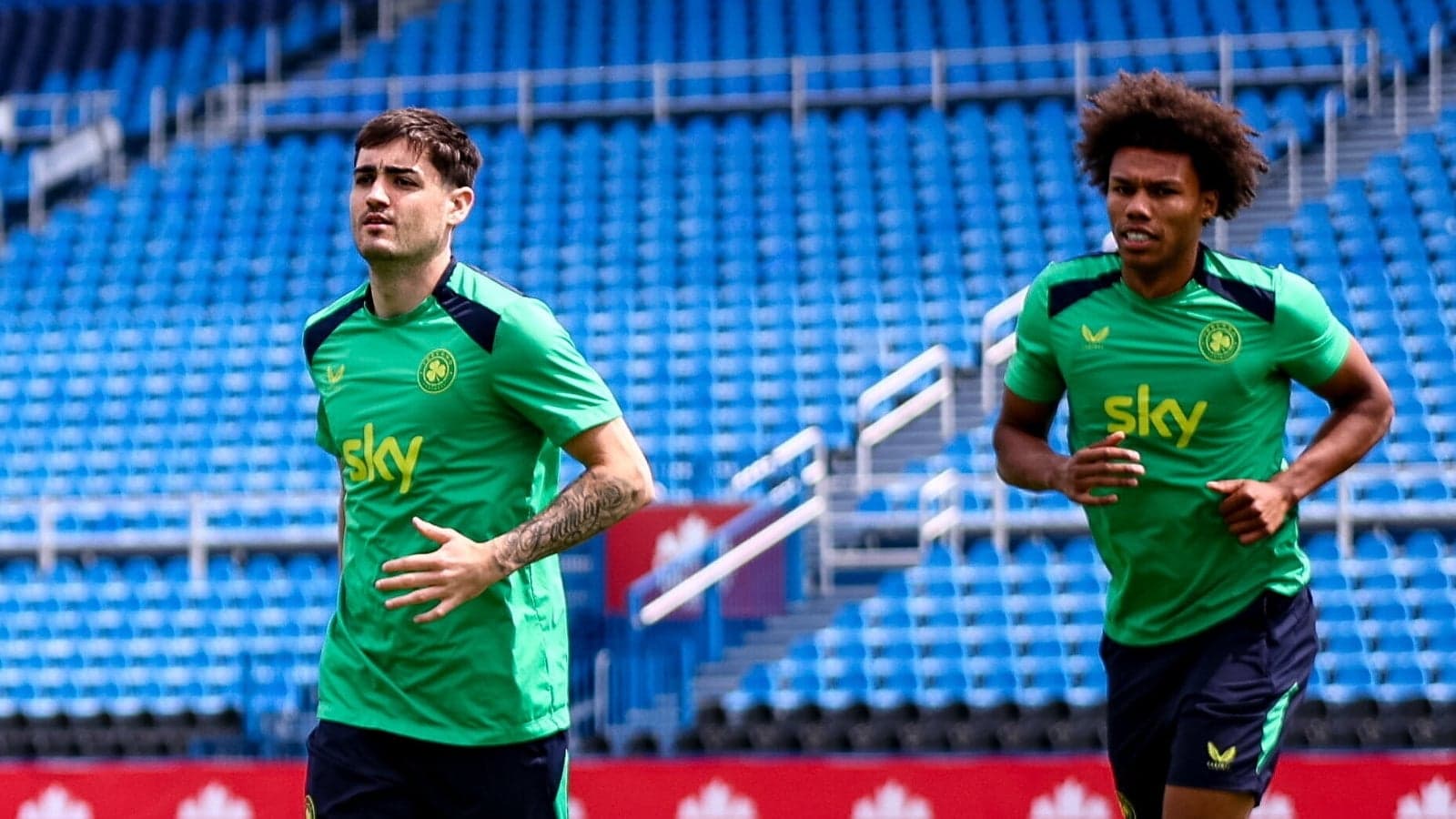 Two players jogging on training pitch Two players jogging on training pitch