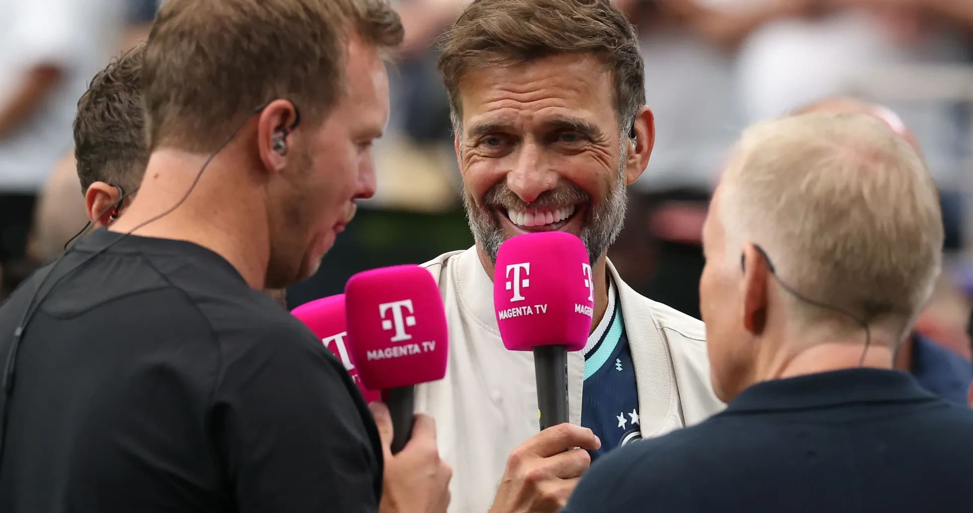 Four presenters holding microphones during a broadcast Four presenters holding microphones during a broadcast