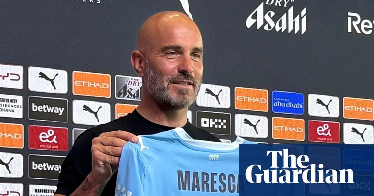 Man holding Manchester City jersey at press conference Man holding Manchester City jersey at press conference