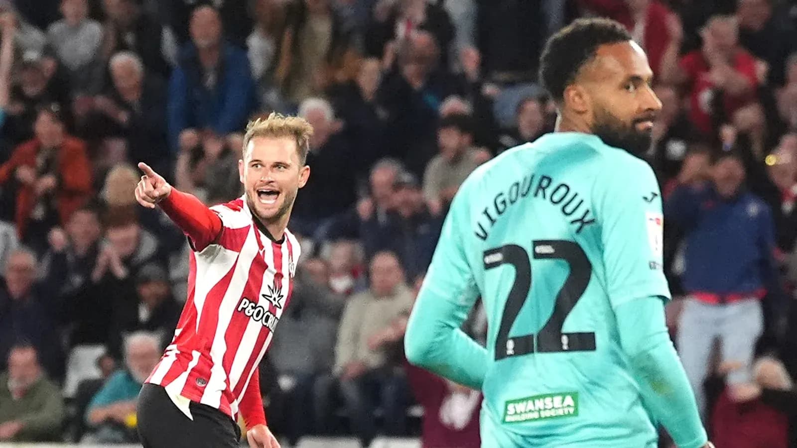 Player celebrating goal while opponent looks on Player celebrating goal while opponent looks on