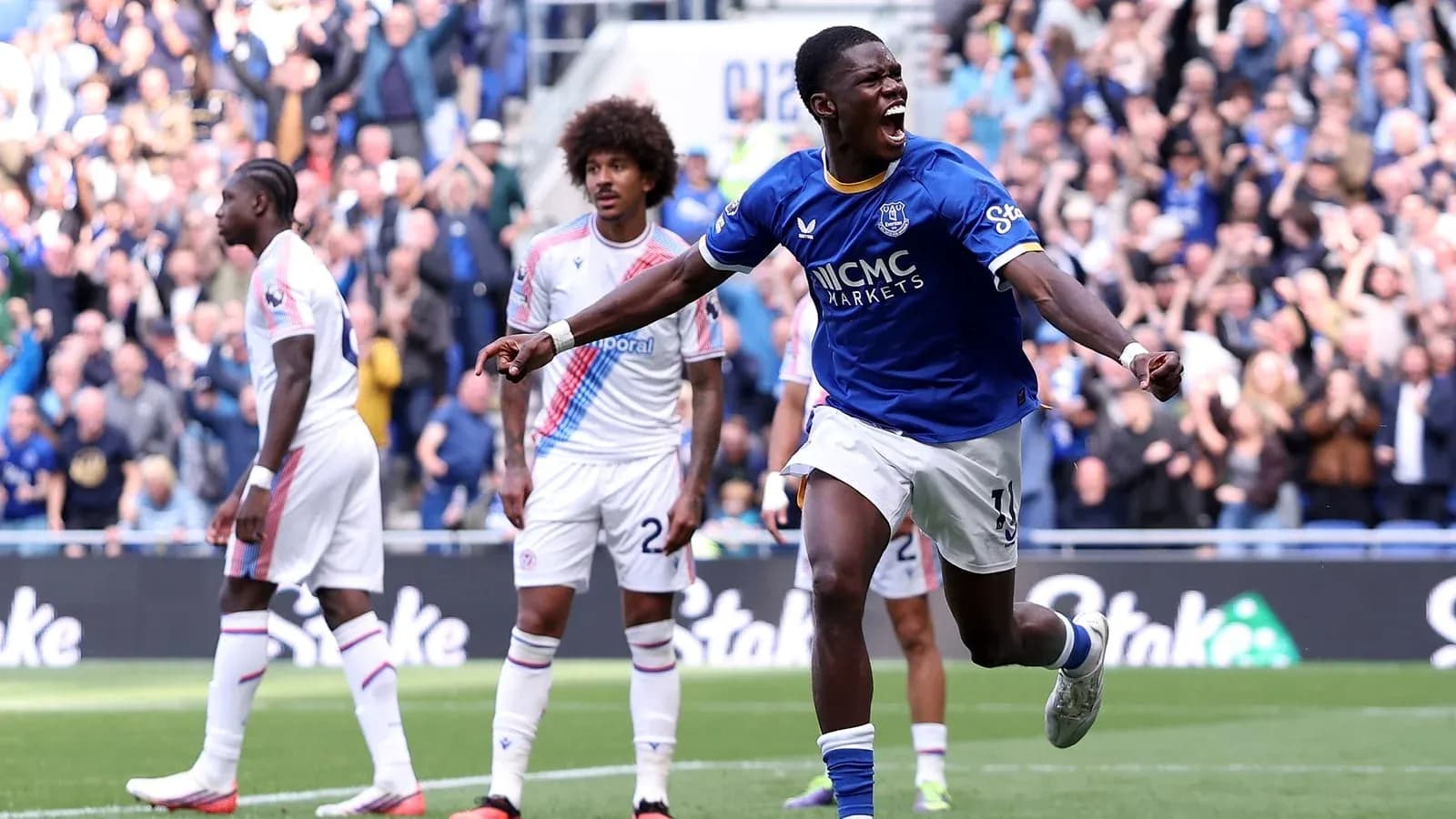 Player celebrating a goal with fans in background Player celebrating a goal with fans in background