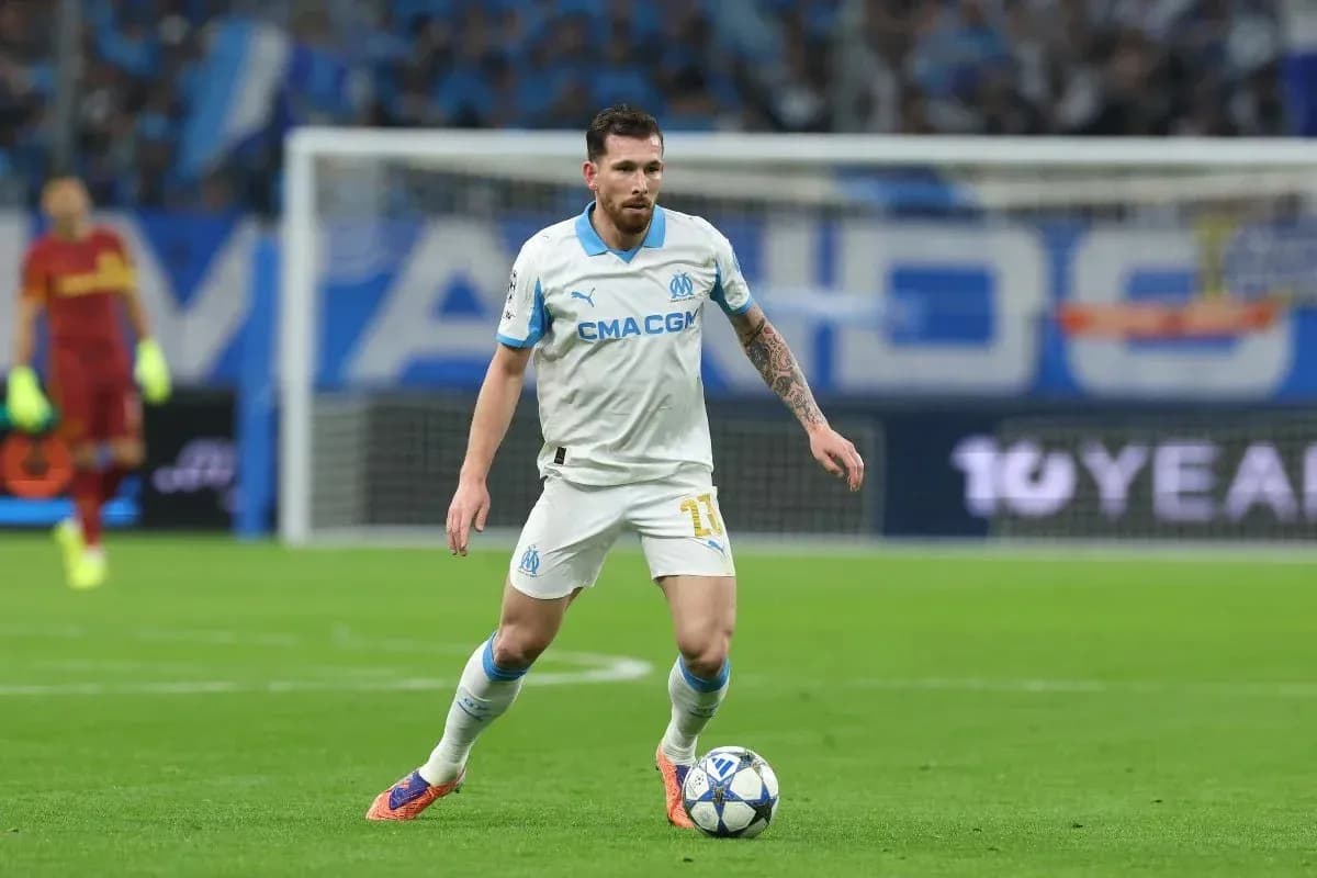 Player in white jersey controlling the ball on field Player in white jersey controlling the ball on field